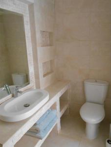 a bathroom with a white sink and a toilet at HydraVista (Coral) in Hydra