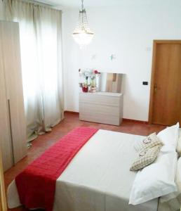 een slaapkamer met een groot wit bed en een rode deken bij la terrazza del silenzio in Fattoria Spedaletto