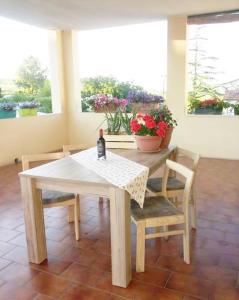een tafel en stoelen met een fles wijn erop bij la terrazza del silenzio in Fattoria Spedaletto