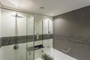 a bathroom with a sink, mirror, and bathtub at Wyndham Dubai Marina in Dubai