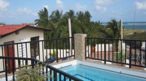 a balcony with a swimming pool and the ocean at Mei Place Apartments in Mombasa