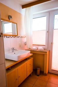 ein Bad mit einem Waschbecken und einem Fenster in der Unterkunft Wohlfühlhotel Alpenrose in Bad Wörishofen