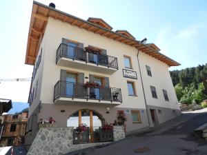 コンメッツァドゥーラにあるAparthotel Dolomites Living&Relaxのバルコニーと花が飾られた建物