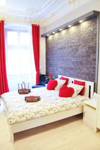 sypialnia z łóżkiem z czerwonymi poduszkami i ceglaną ścianą w obiekcie Grey Rooms we Wrocławiu