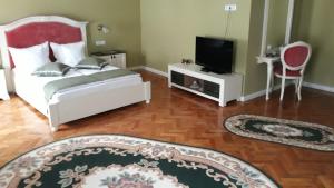 um quarto com uma cama e uma televisão numa mesa em Zum Weissen Lamm Residence em Sibiu