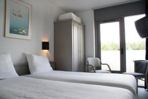a hotel room with two beds and a tv at Fletcher Hotel - Restaurant Nieuwvliet Bad in Nieuwvliet-Bad +17 photos