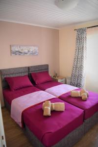 una camera da letto con un letto grande con lenzuola rosa di Kampielo Apartment a Città di Corfù