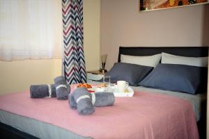 un letto con due animali di peluche e un vassoio di cibo di Kampielo Apartment a Città di Corfù