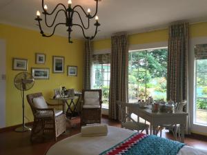 a bedroom with a bed and a table and chairs at Diggersrest Lodge in Haenertsburg