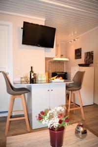 una cucina con un bancone, due sedie e un tavolo di Kampielo Apartment a Città di Corfù