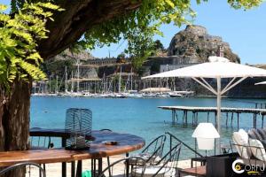 un tavolo con ombrellone accanto a un corpo d'acqua di Kampielo Apartment a Città di Corfù