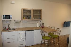 a kitchen with white cabinets and a table and chairs at Apartament Matejki in Łódź