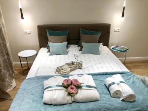 Una cama con dos toallas y dos rosas. en Reichel-Appartements, en Baden-Baden