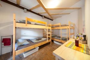 a room with three bunk beds and a table at Hostel Xaxid in Črni Kal