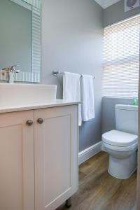 a bathroom with a white sink and a toilet at Brookshill - Protea suite in Somerset West