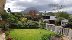 uitzicht op een tuin met een tuin met bergen op de achtergrond bij Brookshill - Protea suite in Somerset West