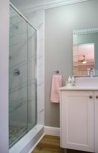 a bathroom with a glass shower and a sink at Brookshill - Protea suite in Somerset West