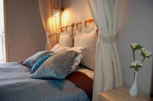 ein Schlafzimmer mit einem Bett mit Kissen und einem Vorhang in der Unterkunft Friedleina 7 Kamienica Prezydencka in Krakau