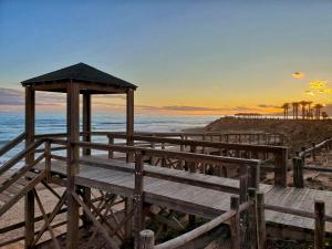 muelle de madera con cenador en la playa en Oasis del Toyo, en Retamar