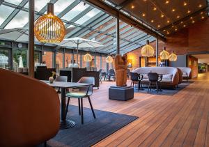 a lobby with tables and chairs in a building at Pharmakon Hotel & Conferencecenter in Hillerød