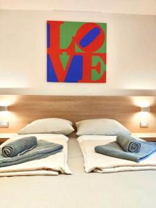 a bed with two pillows and a painting on the wall at Kriemhilde Dependance in Worms