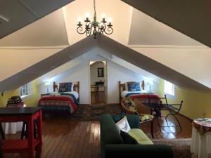 an attic room with two beds and a chandelier at Diggersrest Lodge in Haenertsburg