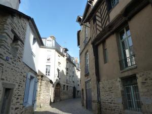 Une allée dans une vieille ville avec des bâtiments en pierre dans l'établissement Le Point d'Orgue, à Rennes