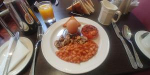 a plate of food with an egg and beans on a table at Russell Hotel in Royal Tunbridge Wells
