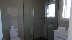 uma casa de banho com um chuveiro, um WC e um lavatório. em Bayfield Motel and Apartment em Dunedin
