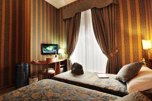 ein Hotelzimmer mit 2 Betten und einem Fenster in der Unterkunft HS 311 in Rom
