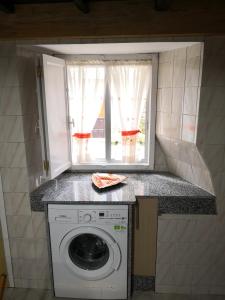 a washing machine in a kitchen with a window at Casa Carlán in Melide