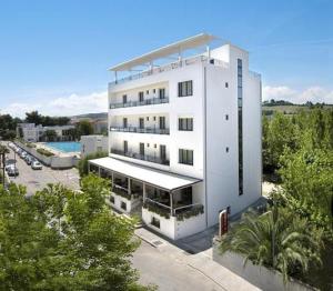 un alto edificio bianco con una piscina di fronte di Hotel Conchiglia a Senigallia