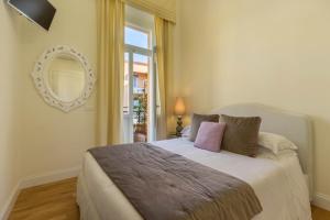 a bedroom with a bed with a mirror and a window at BB22 Cagliari in Cagliari
