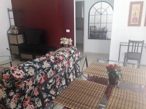 ein Wohnzimmer mit einem Sofa, 2 Tischen und einem TV in der Unterkunft Casa Leli in Candelaria