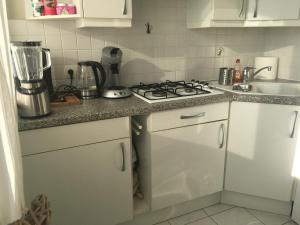 a kitchen with white cabinets and a stove top oven at Casinostraat 16/67 in Blankenberge