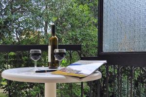 a table with a bottle of wine and two glasses at Hotel Orpheus in Gouvia