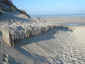 een hek in het zand op een strand bij La Garenne in Camiers