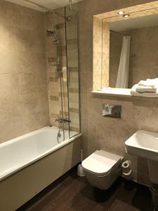 een badkamer met een bad, een toilet en een wastafel bij The Troll Cart Wetherspoon in Great Yarmouth