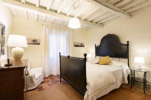 una camera da letto con un letto grande con una grande testiera di Casa Arancio - Fattoria la Speranza, Case Toscane ad Anghiari