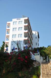 un grand bâtiment blanc avec des fleurs devant lui dans l'établissement Hotel Royal, à Alanya