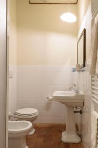 a white bathroom with a toilet and a sink at Casa Ribes - Fattoria la Speranza, Case Toscane in Anghiari +31 photos