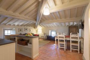 a kitchen and living room with a table and chairs at Casa Ribes - Fattoria la Speranza, Case Toscane in Anghiari