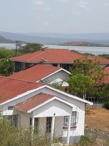 biały dom z czerwonymi dachami w obiekcie Sandai Resort Lake Baringo w mieście Ol Kokwe