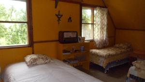 a bedroom with a bed and a tv and two windows at Viruna Farm in Kiraste