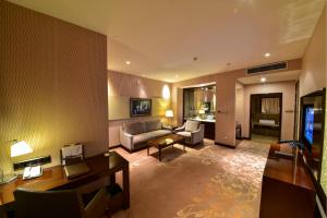 a large living room with a couch and a television at Ritan Hotel Downtown Beijing in Beijing