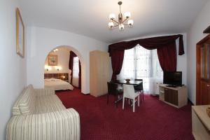 Habitación de hotel con 1 cama, escritorio y 1 dormitorio en Vila Acvila, en Sinaia