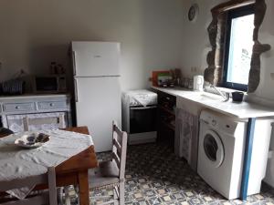 a kitchen with a white refrigerator and a table with a table sidx sidx at Fig Leaf House in Elounda