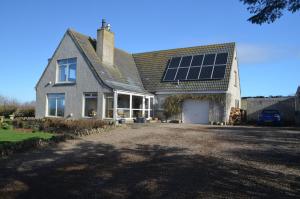a house with solar panels on the roof at Aurora Bed & Breakfast in Castletown