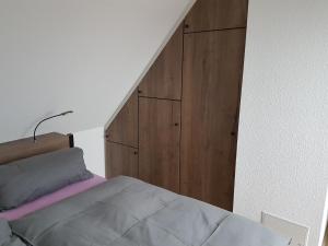 Schlafzimmer mit einem Bett und einem Holzschrank in der Unterkunft DOMizil Xanten in Xanten