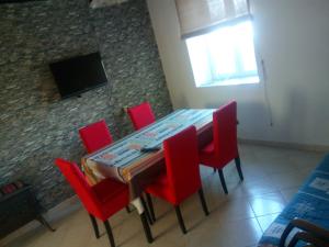 a dining room with a table and red chairs at Nevera Apartments Pašman,Banj in Banj